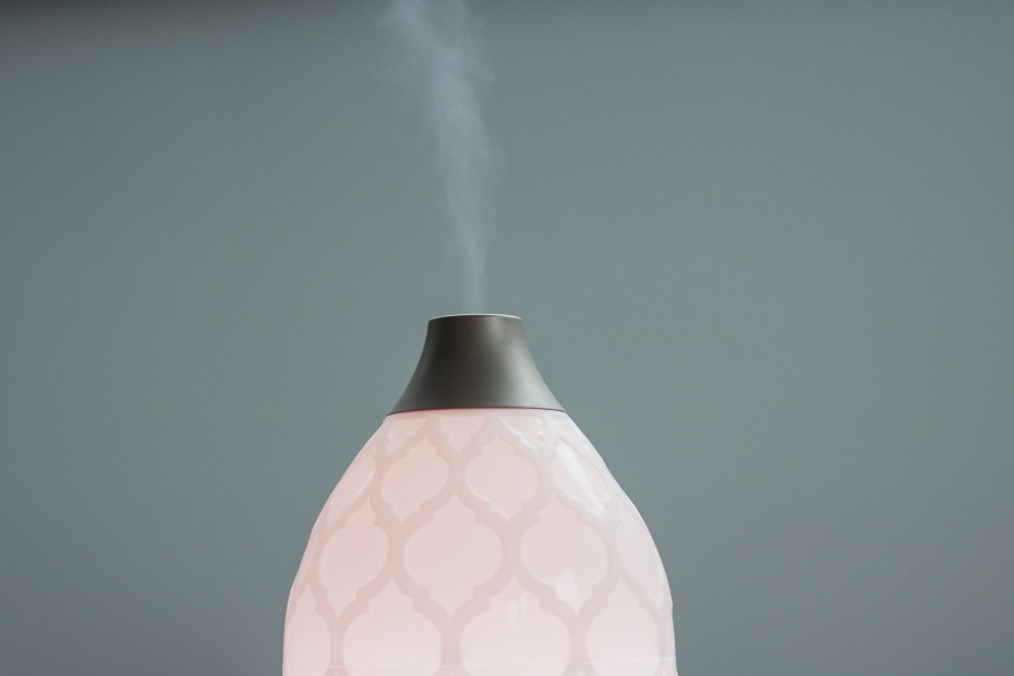A cream coloured scent diffuser on a grey background