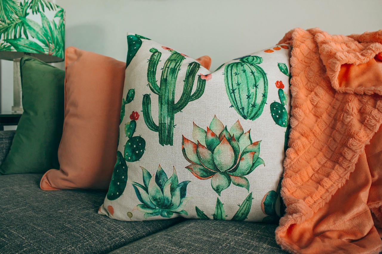 Orange throw and patterned scatter cushions on a sofa