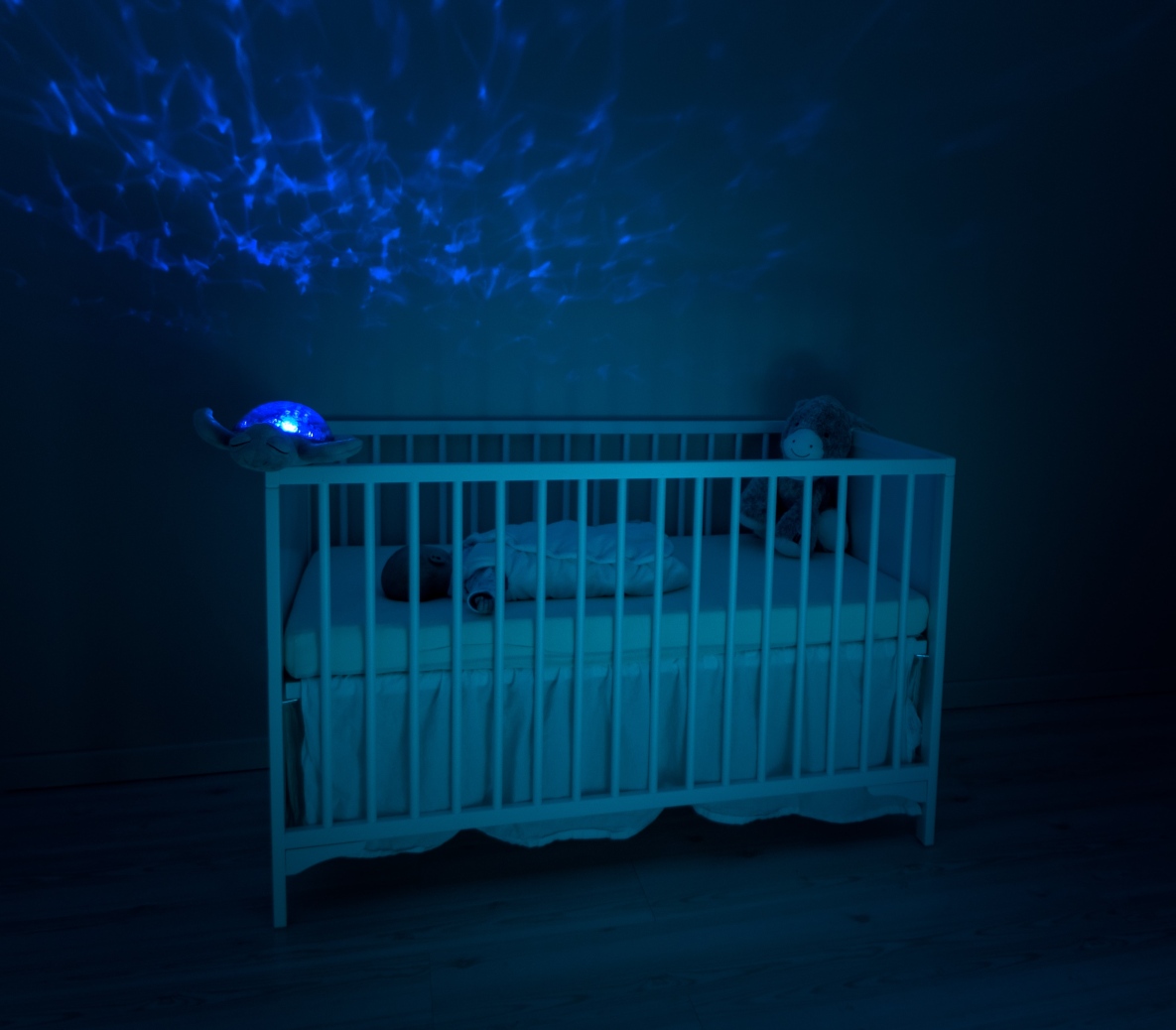 A cot in a nursery with blue lighting