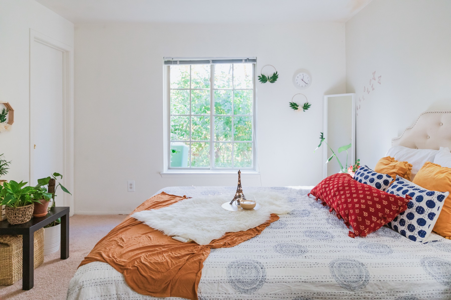 An image of a white bedroom with colourful decor