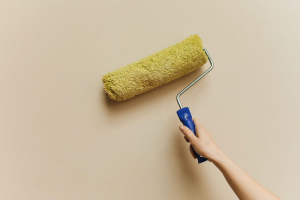 An image of someone painting a wall with a paint roller