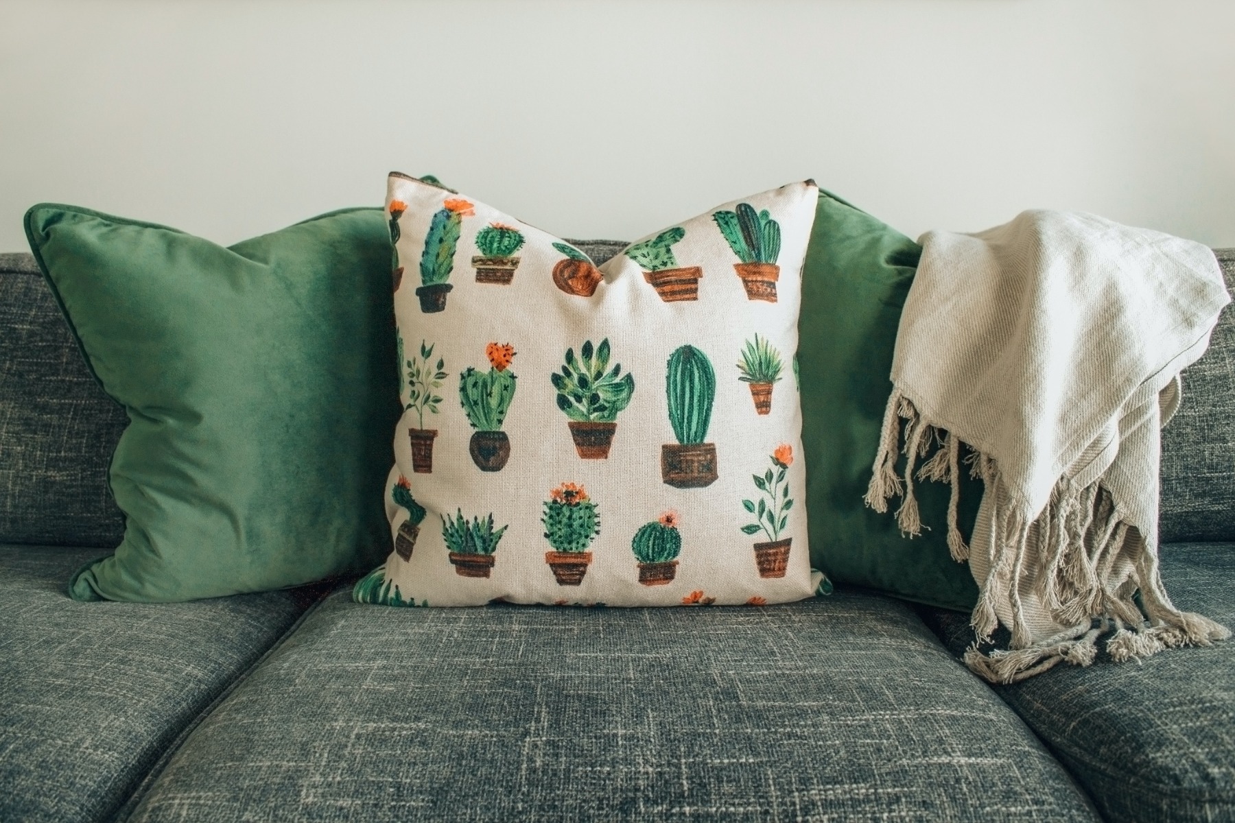 An image of cushions and a blanket on a sofa